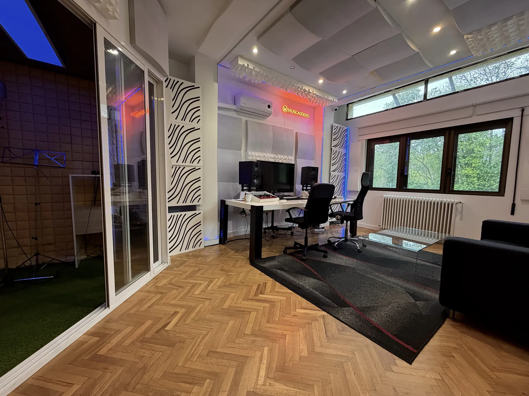 Vista lateral del estudio de MusicAdders con la cabina de voz acristalada
